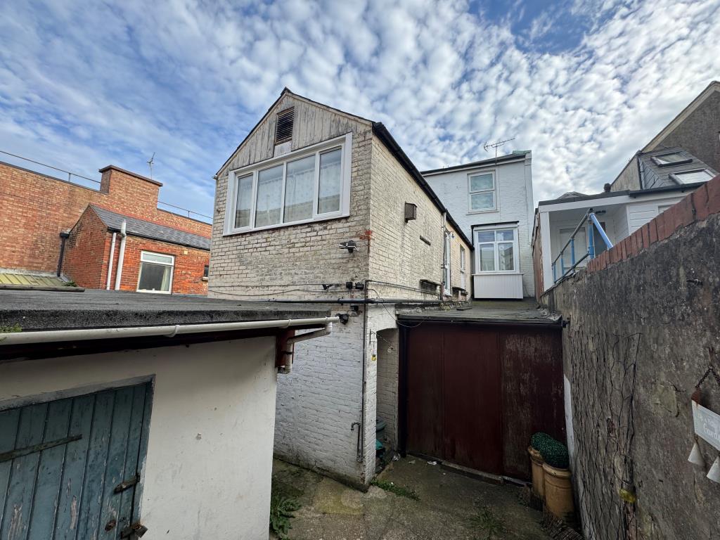 Lot: 94 - DOUBLE-FRONTED HIGH STREET SHOP WITH LARGE REAR STORES WITH POTENTIAL AND FREEHOLD INTEREST IN TWO FLATS OVER - Rear Aspect